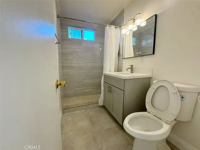 a bathroom with a toilet sink vanity and mirror
