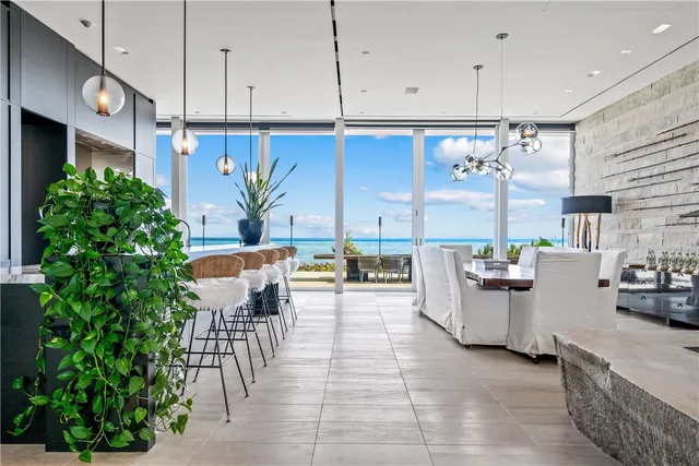 a kitchen with stainless steel appliances kitchen island granite countertop a table chairs in it and a window