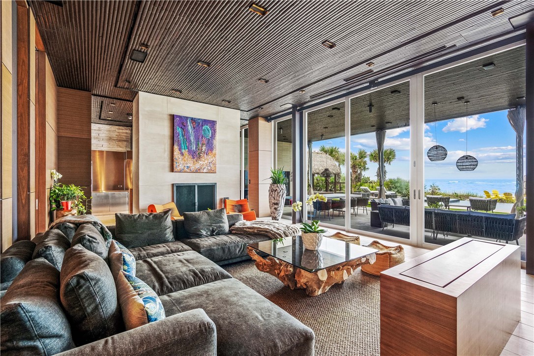 3700 Ocean Drive Vero Beach, FL 32963 - Photo 13 of 36 a living room with furniture large windows and a fireplace
