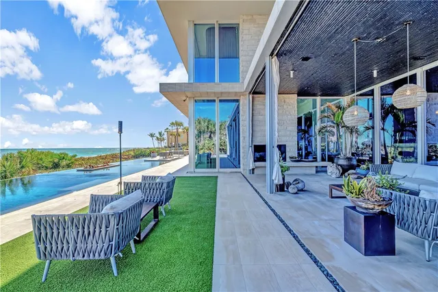 a view of a patio with couches table and chairs and potted plants