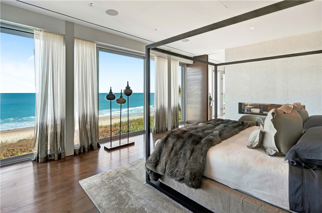 3700 Ocean Drive Vero Beach, FL 32963 - Photo 21 of 36 a bedroom with a bed and a large window with wooden floor