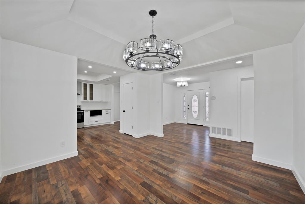 3410 Faulkner Drive Rowlett, TX 75088 - Photo 11 of 38 a view of an empty room with wooden floor and a kitchen