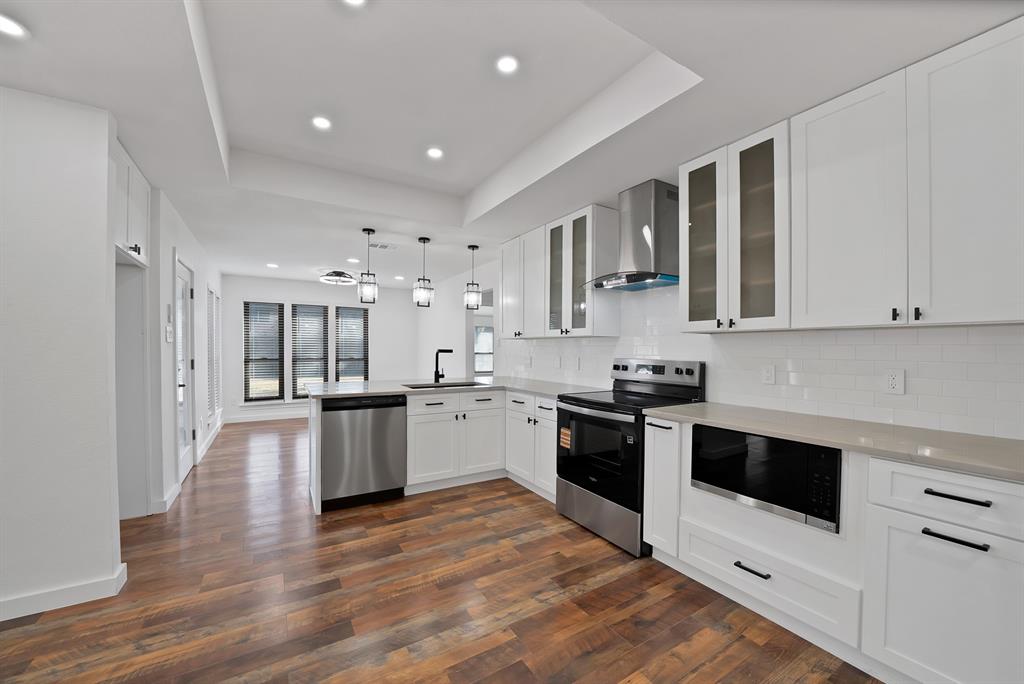 3410 Faulkner Drive Rowlett, TX 75088 - Photo 12 of 38 a large kitchen with stainless steel appliances granite countertop a large center island and a sink