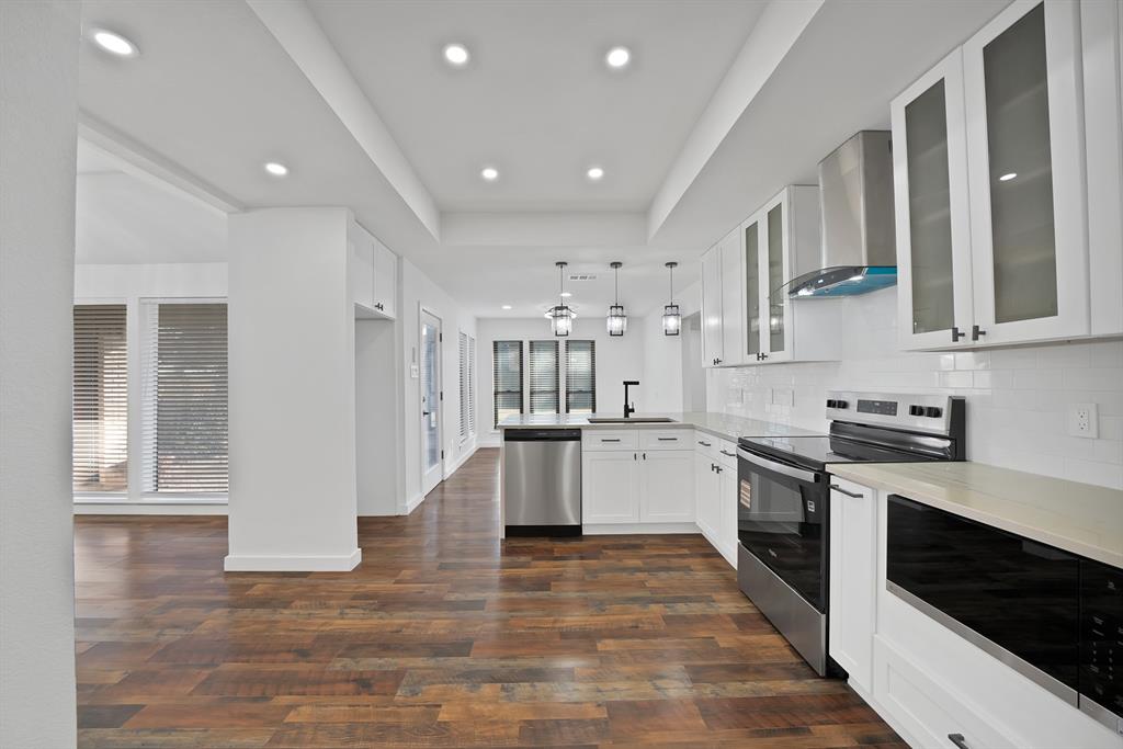 3410 Faulkner Drive Rowlett, TX 75088 - Photo 14 of 38 a large kitchen with stainless steel appliances granite countertop a stove and a sink
