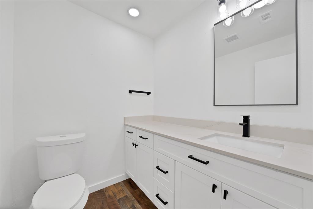 3410 Faulkner Drive Rowlett, TX 75088 - Photo 30 of 38 a bathroom with a toilet sink and mirror