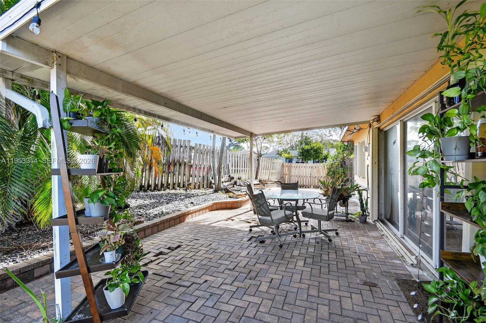 1712 High Ridge Road Lake Worth, FL 33461 - Photo 38 of 43 a view of a patio with chairs and floor to ceiling window with garden
