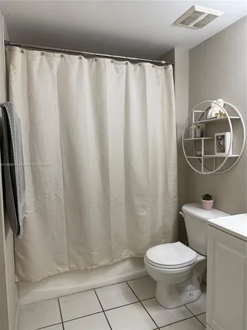 a bathroom with a toilet and a shower curtain