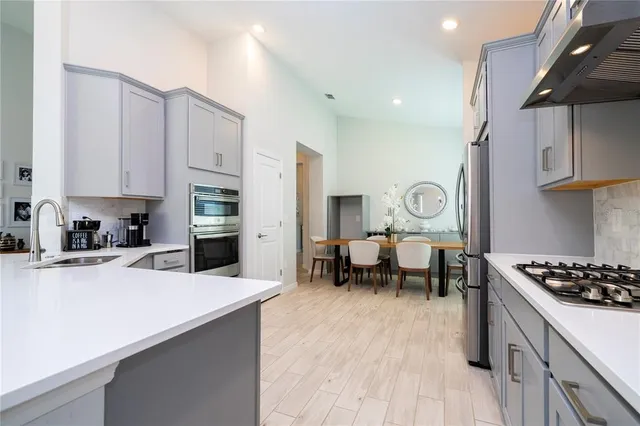 a kitchen with stainless steel appliances granite countertop a refrigerator stove and white cabinets