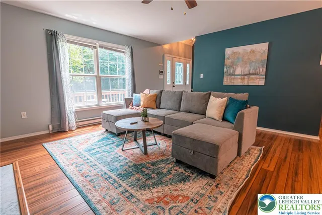 a living room with furniture a fireplace and a large window