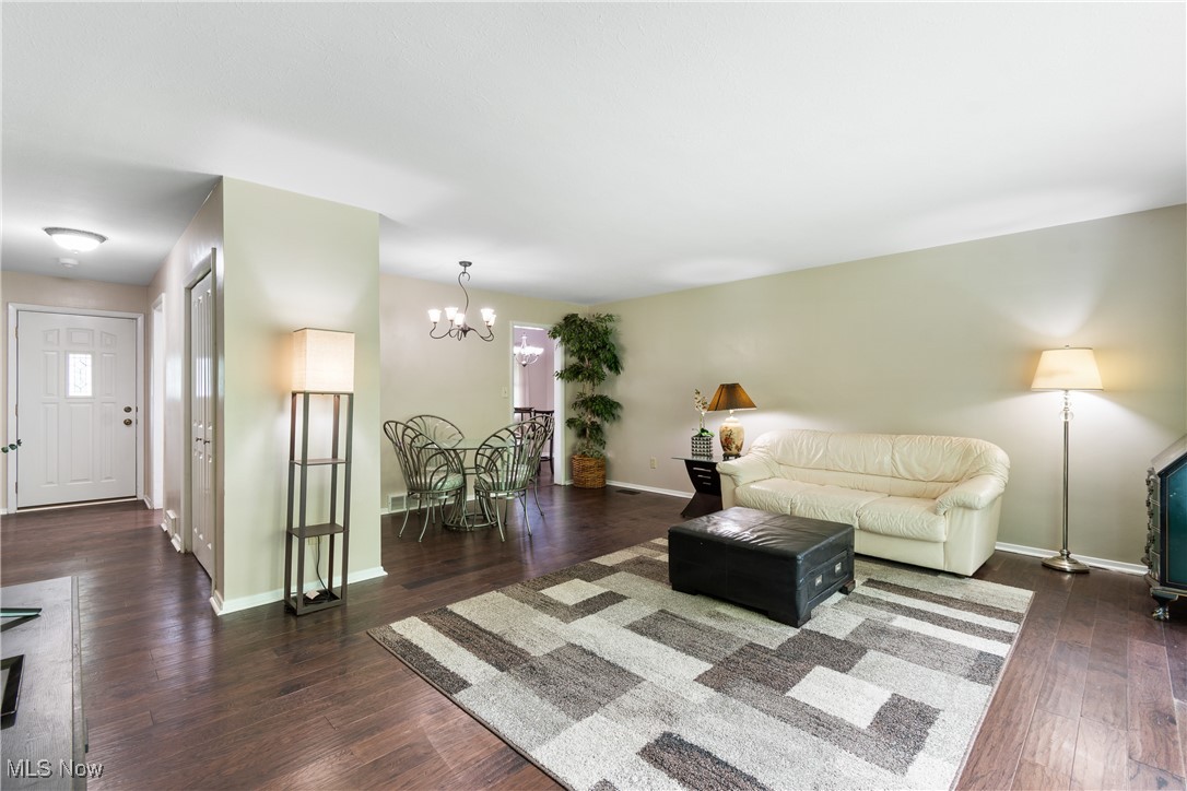 6751 Glenview Road Cleveland, OH 44143 - Photo 6 of 31 Living room featuring a chandelier, dark wood-style flooring, and baseboards