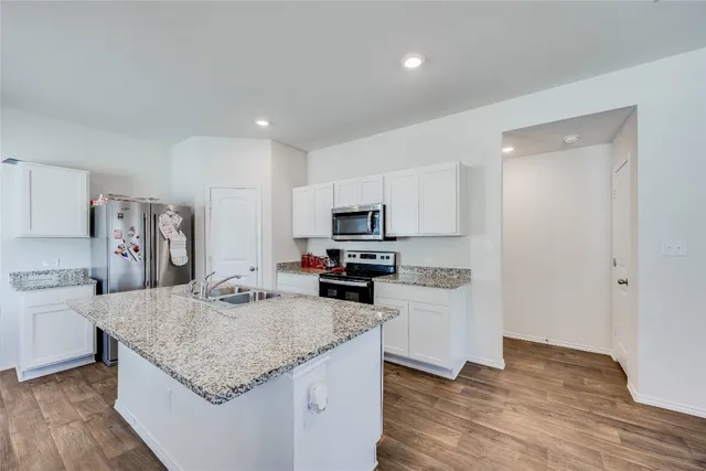 a kitchen with granite countertop a refrigerator and a sink