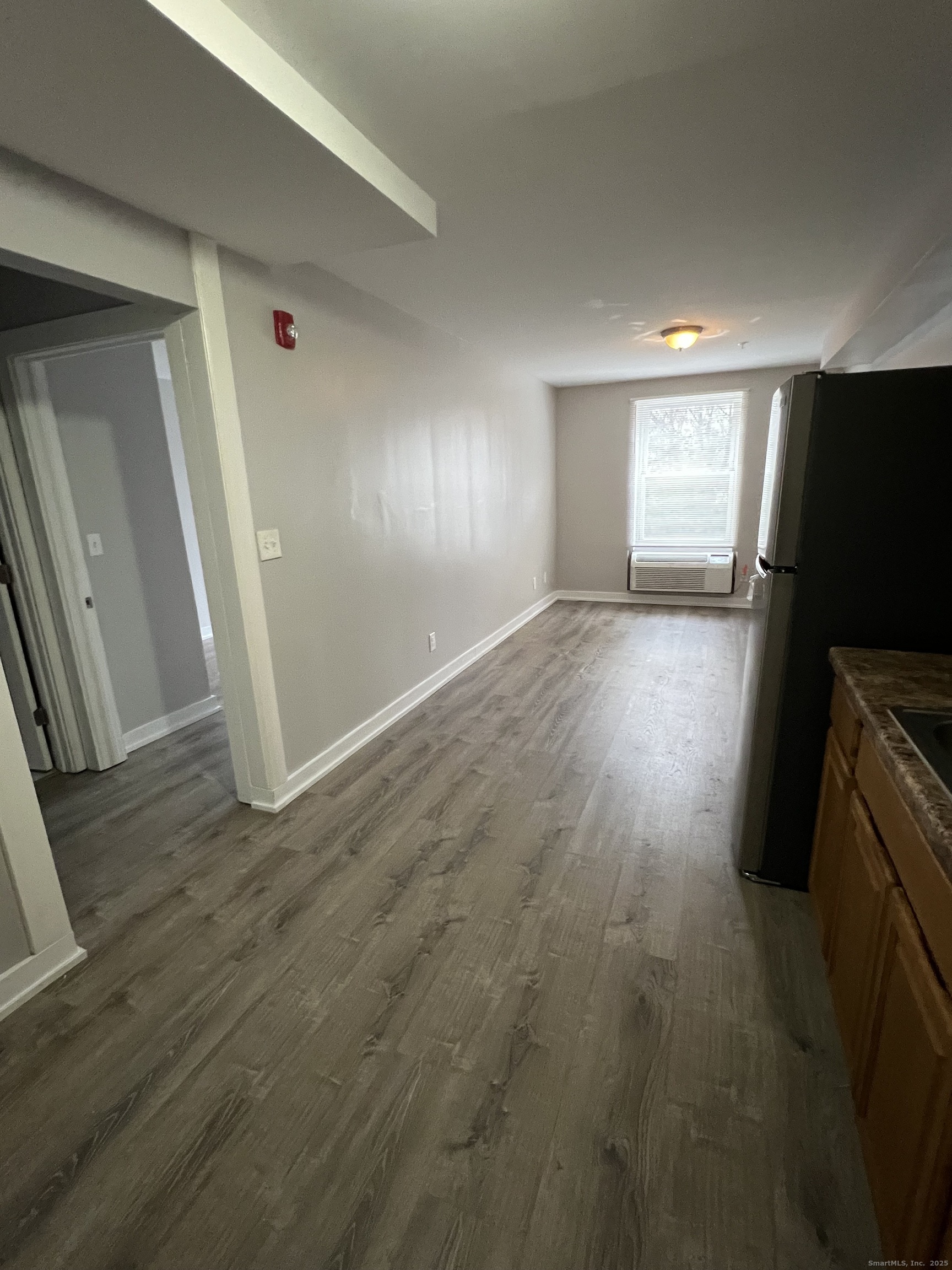 385 Putnam Avenue, Unit 5 Hamden, CT 06517 - Photo 3 of 13 an empty room with wooden floor and windows