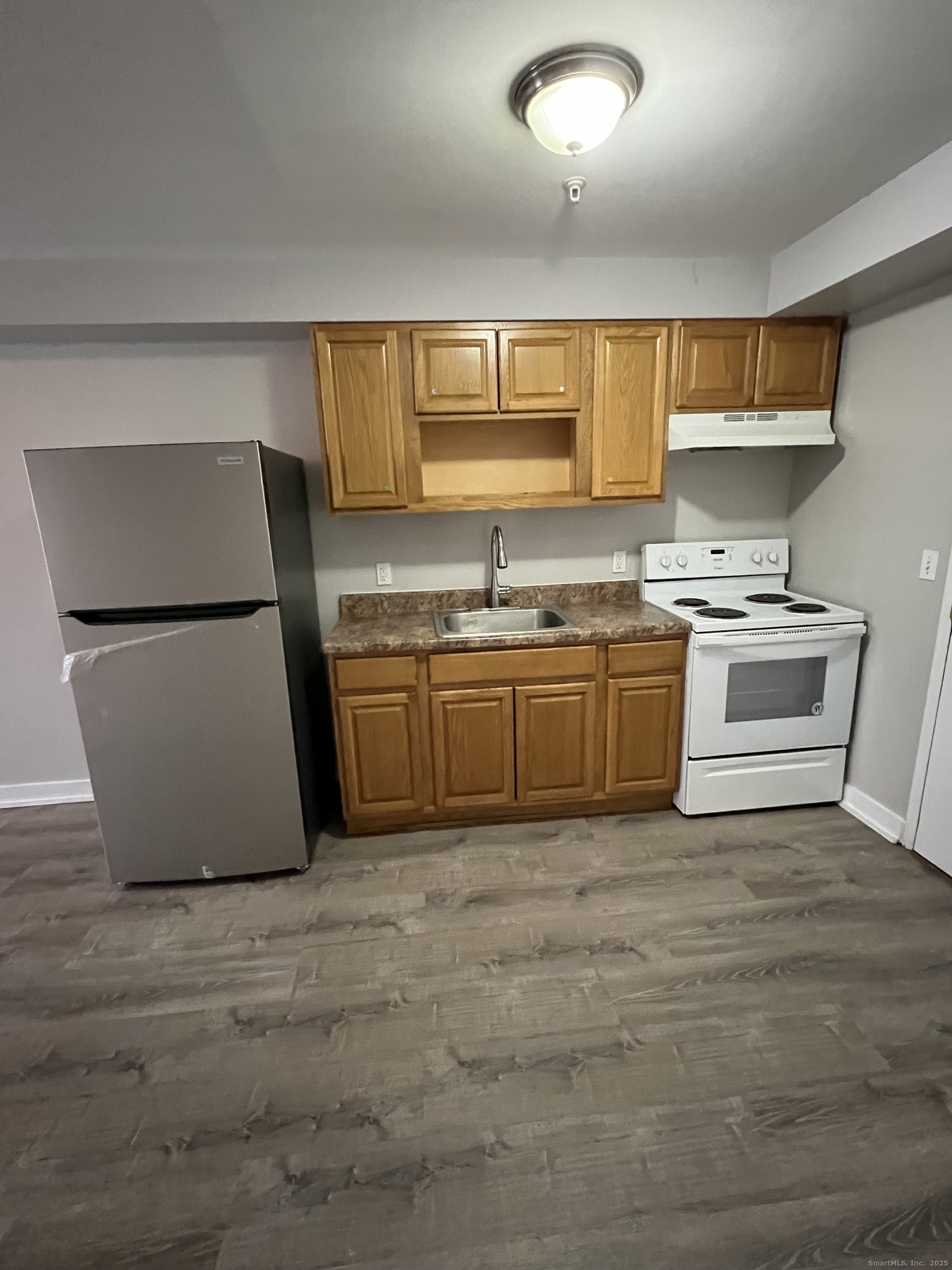 385 Putnam Avenue, Unit 5 Hamden, CT 06517 - Photo 4 of 13 a kitchen with a sink a stove and a refrigerator