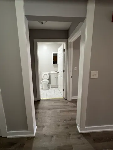 a view of a hallway with wooden floor and a living room