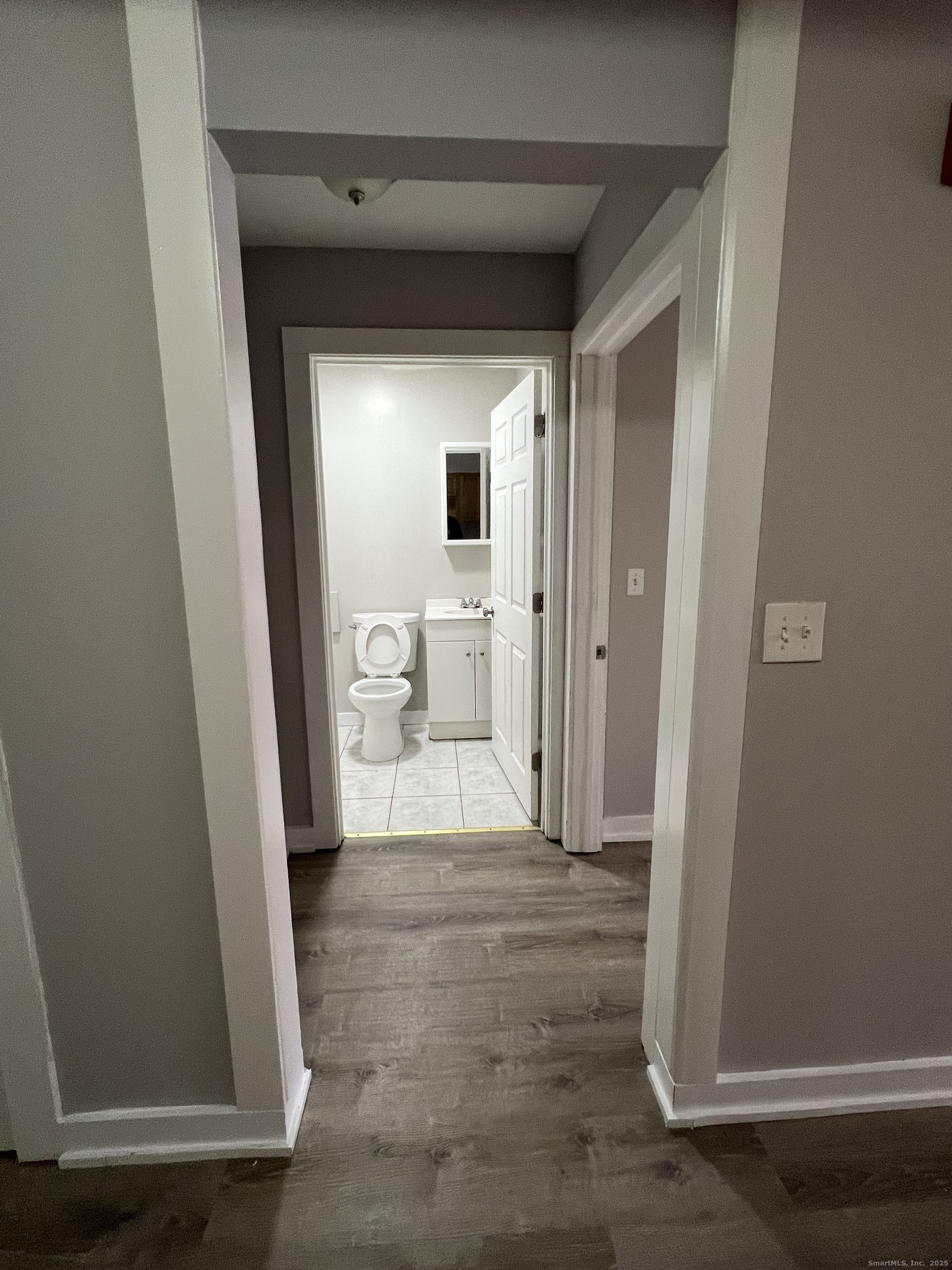 385 Putnam Avenue, Unit 5 Hamden, CT 06517 - Photo 7 of 13 a view of a hallway with wooden floor and a living room