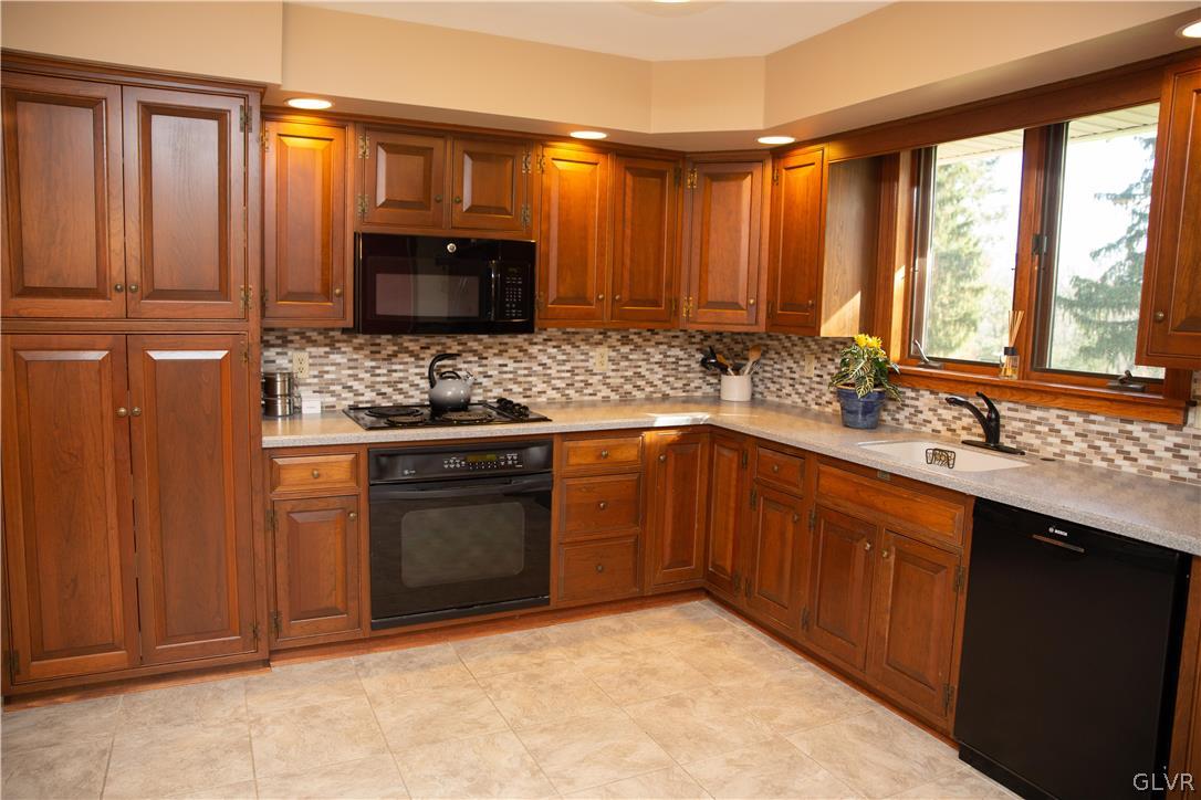 1909 Blue Barn Road Orefield, PA 18069 - Photo 9 of 39 a kitchen with stainless steel appliances granite countertop a stove a sink and a microwave