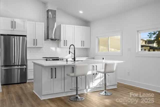 a kitchen with a sink cabinets stainless steel appliances and a window