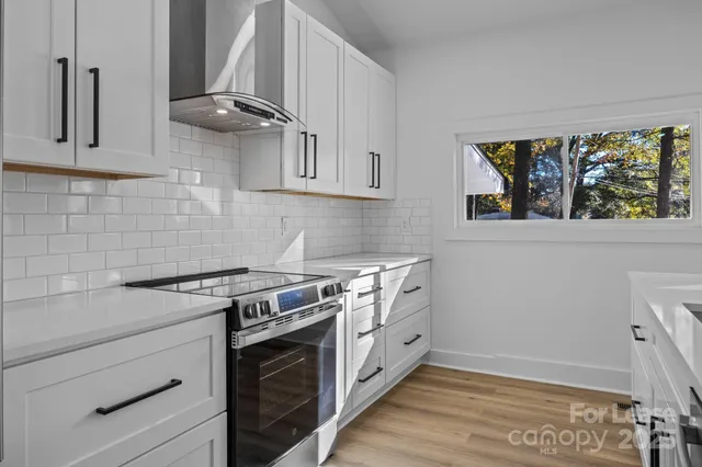 a kitchen with stainless steel appliances white cabinets and a stove
