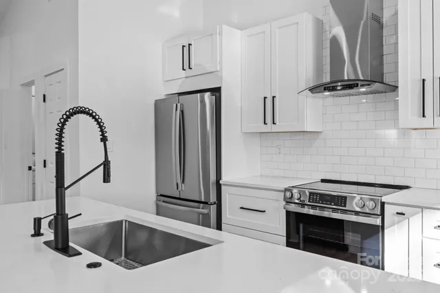 a kitchen with stainless steel appliances a sink a stove and a refrigerator