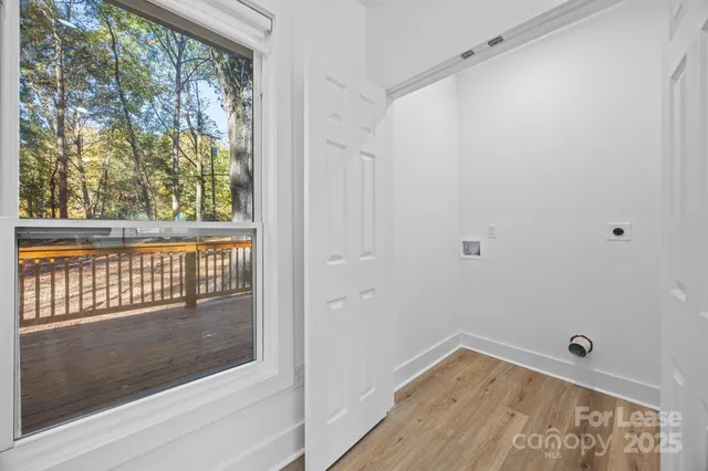 a view of a small space with wooden floor and a window