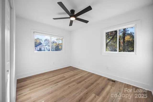 a view of empty room with wooden floor