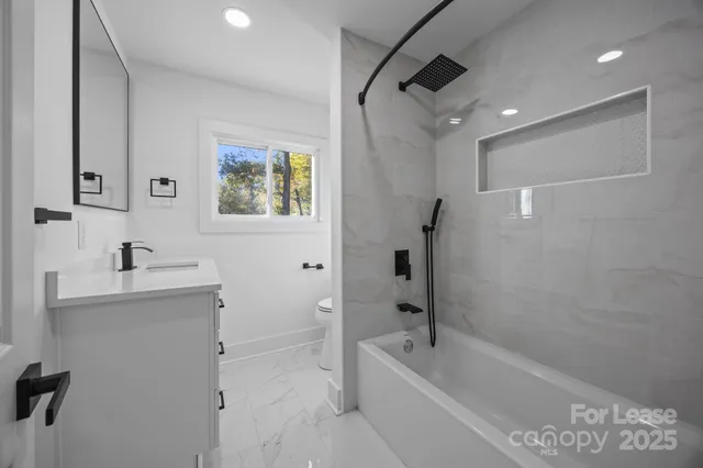 a bathroom with a tub a sink and mirror