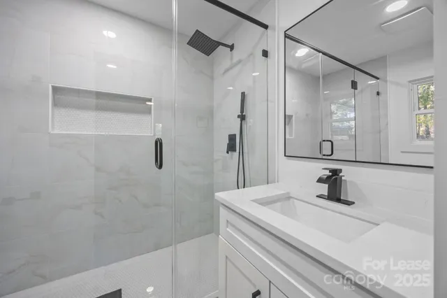 a bathroom with a sink a mirror and shower