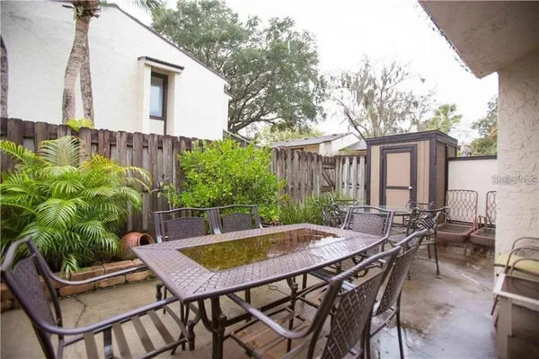 a view of a patio with table and chairs and potted plants