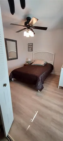 a bed room with a bed and a ceiling fan