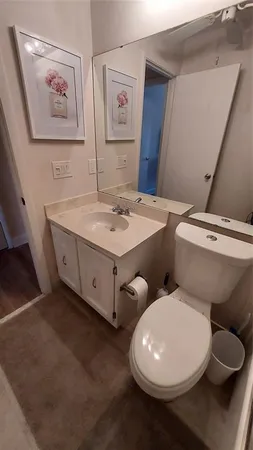 a bathroom with a toilet sink and mirror
