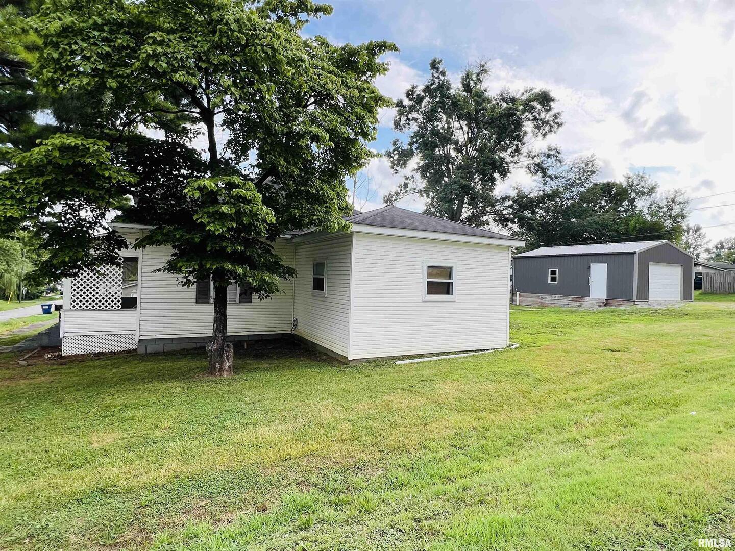 2417 1st Street Eldorado, IL 62930 - Photo 3 of 21 a front view of a house with a garden and trees