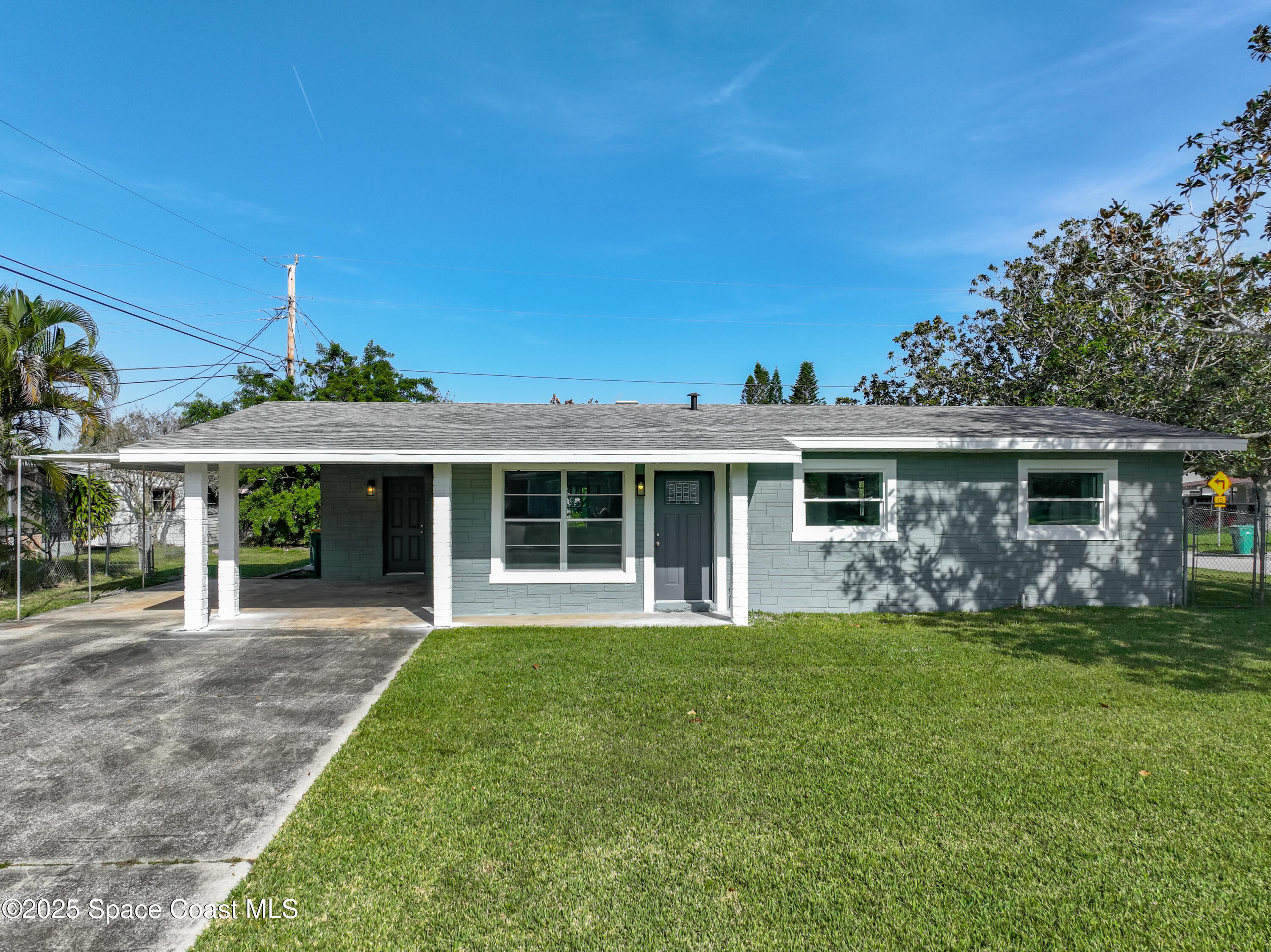2340 Iowa Drive Melbourne, FL 32935 - Photo 3 of 47 a front view of a house with a garden and porch