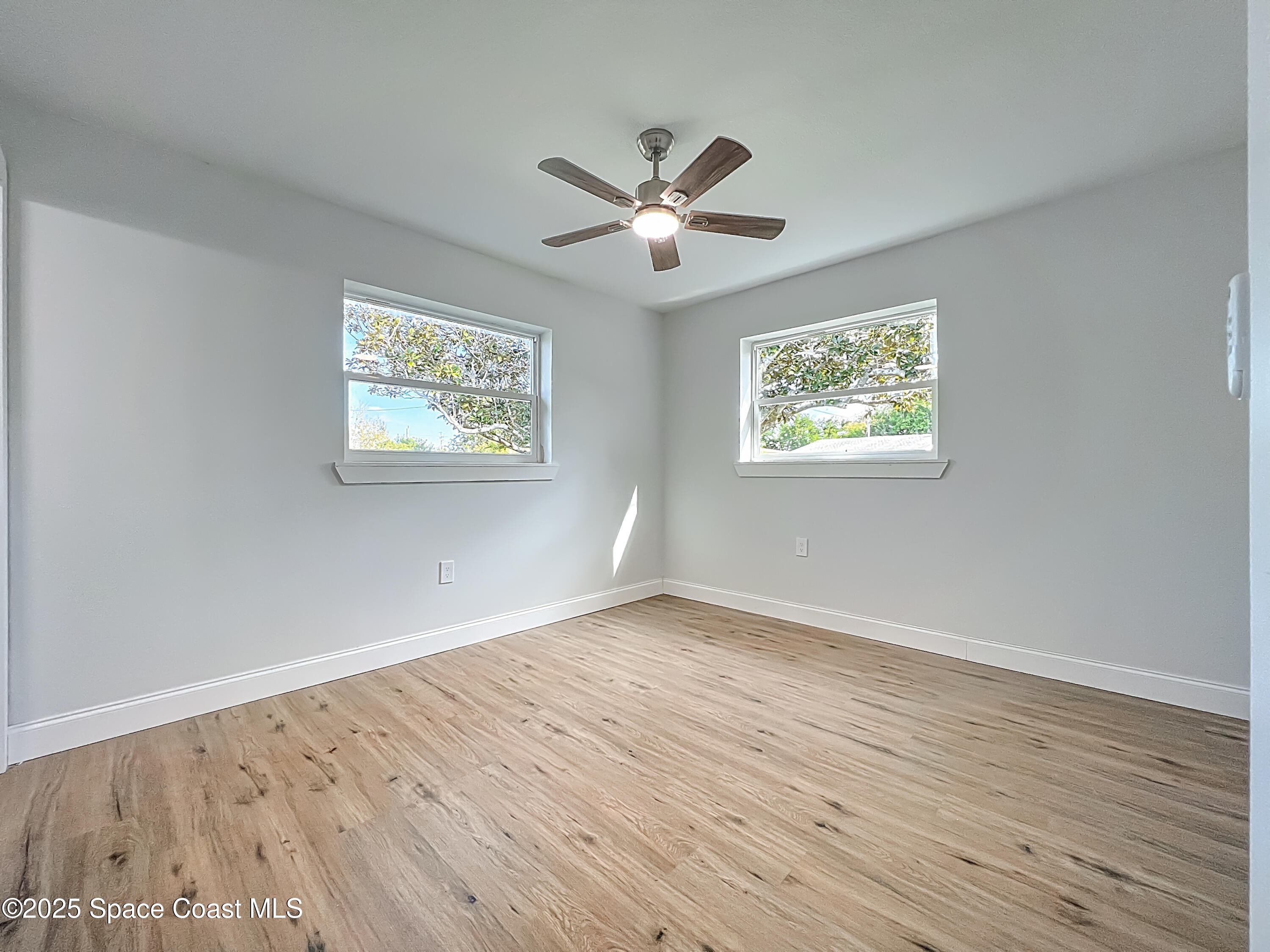 2340 Iowa Drive Melbourne, FL 32935 - Photo 33 of 47 a view of an empty room with wooden floor and a window