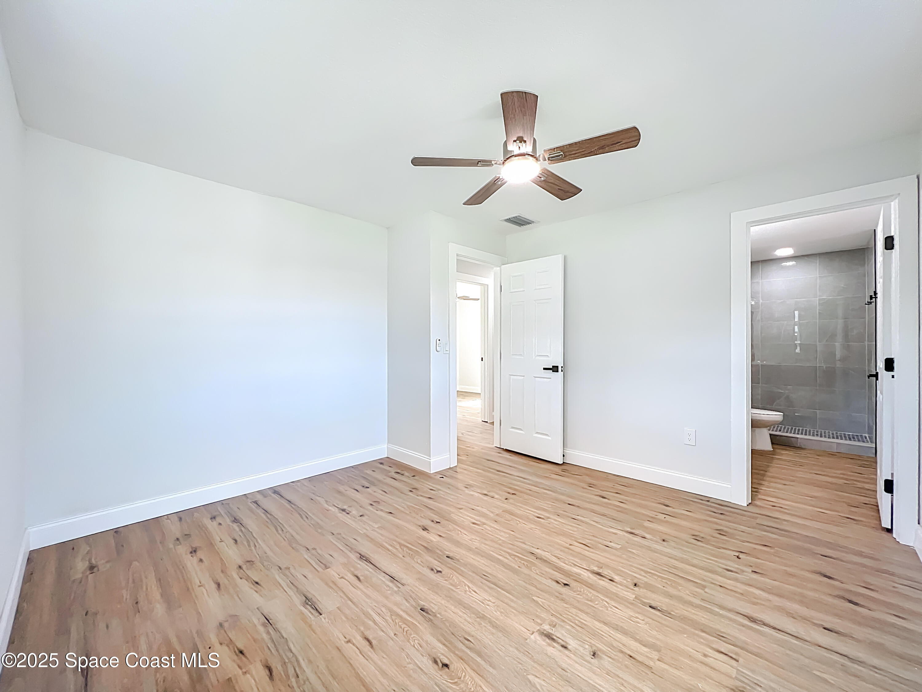 2340 Iowa Drive Melbourne, FL 32935 - Photo 34 of 47 an empty room with wooden floor and windows