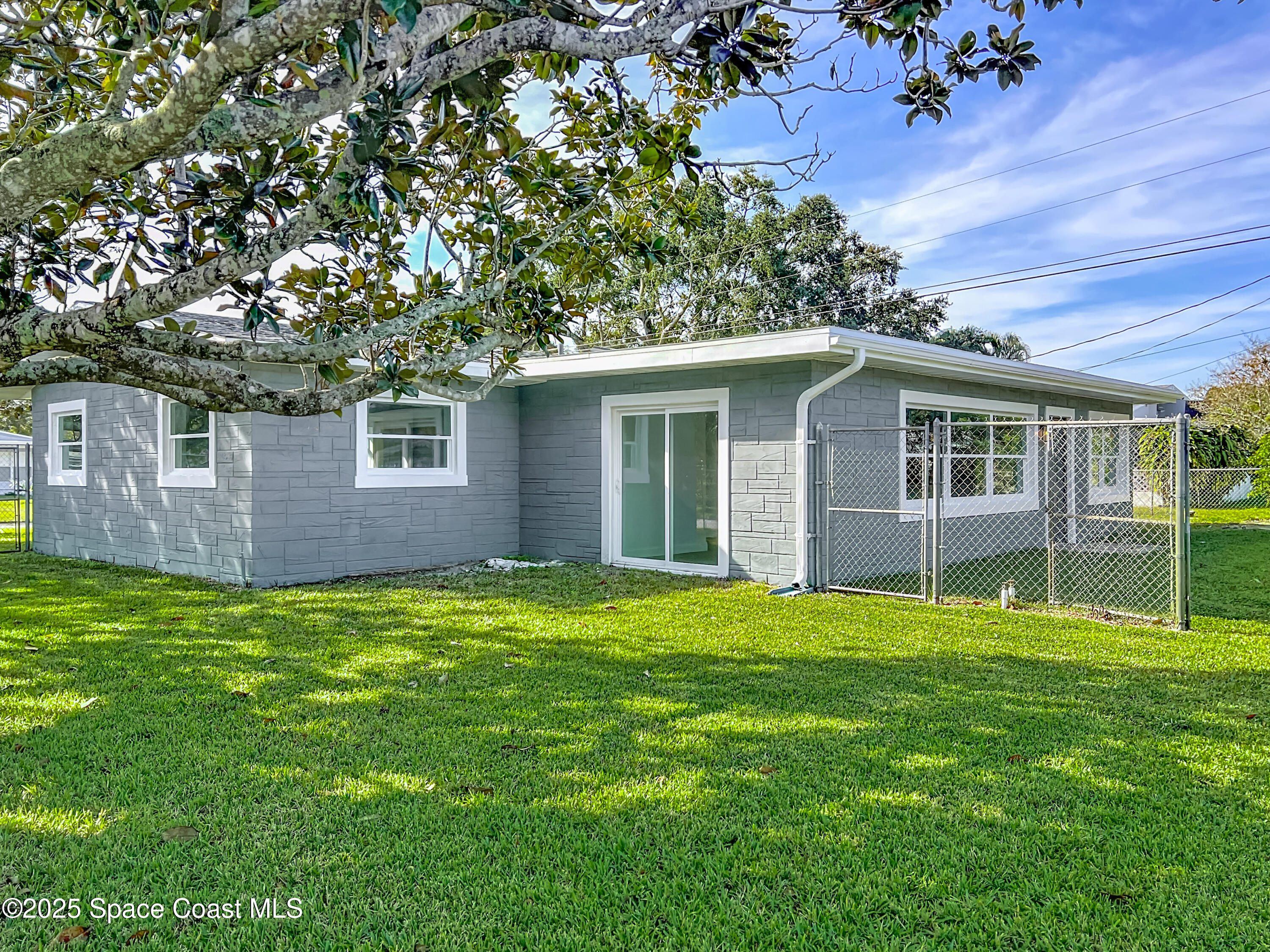 2340 Iowa Drive Melbourne, FL 32935 - Photo 42 of 47 a backyard of a house with large trees and plants