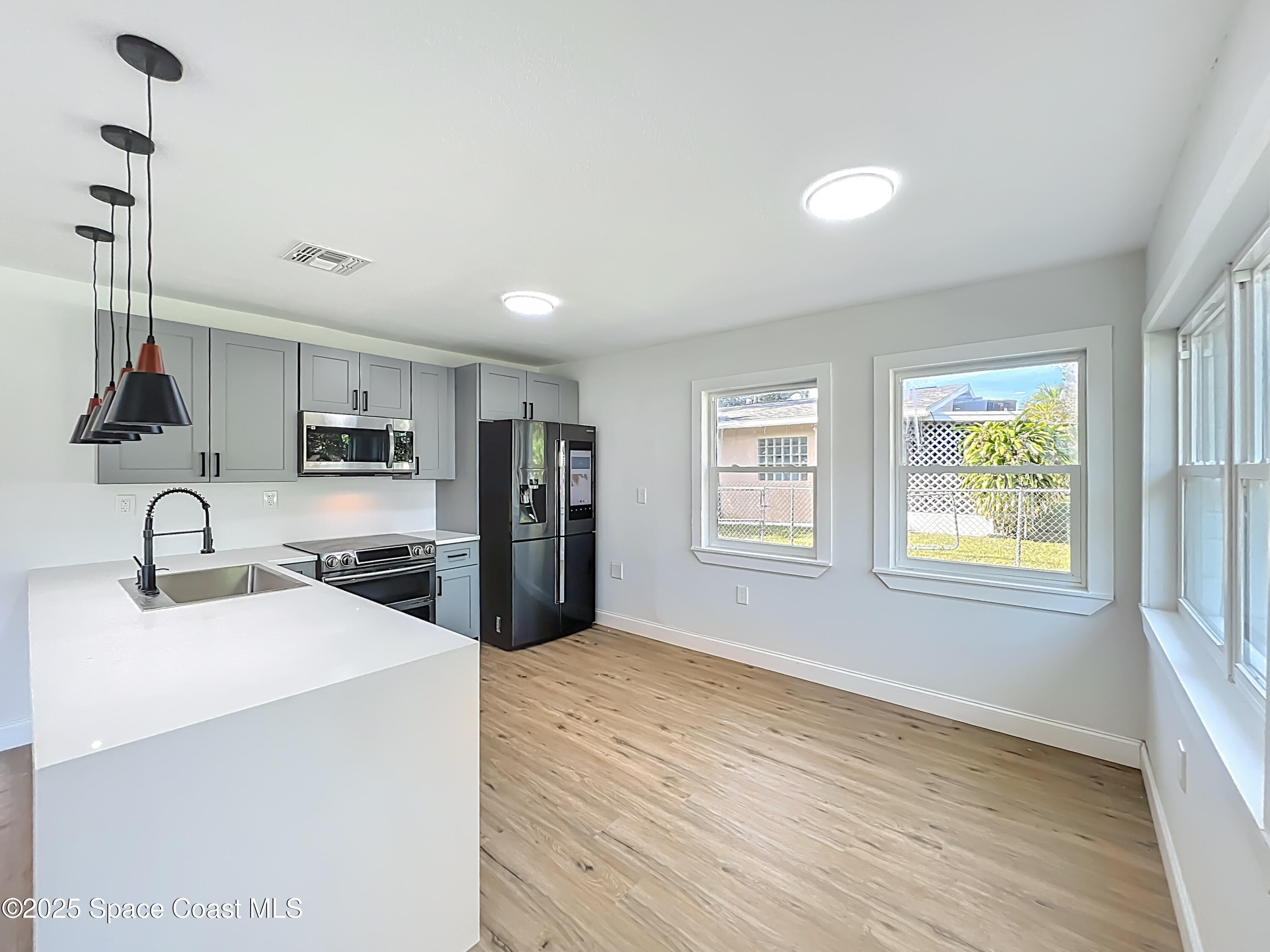 2340 Iowa Drive Melbourne, FL 32935 - Photo 5 of 47 a kitchen with stainless steel appliances granite countertop a sink a stove a refrigerator cabinets and a window
