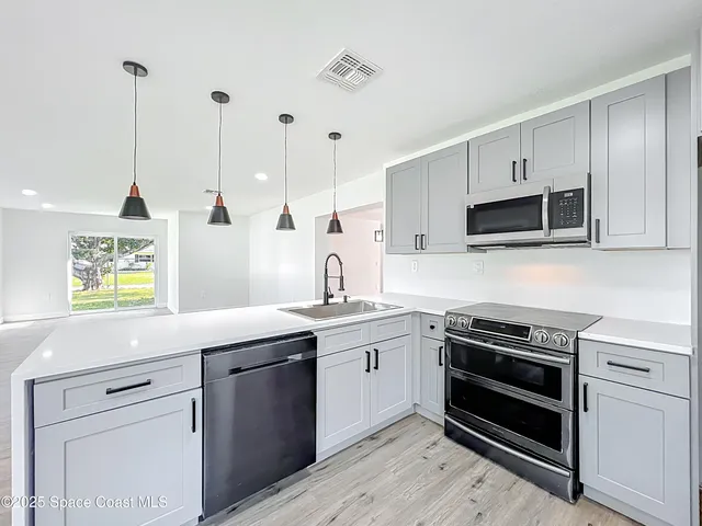 a kitchen with a sink stove and microwave