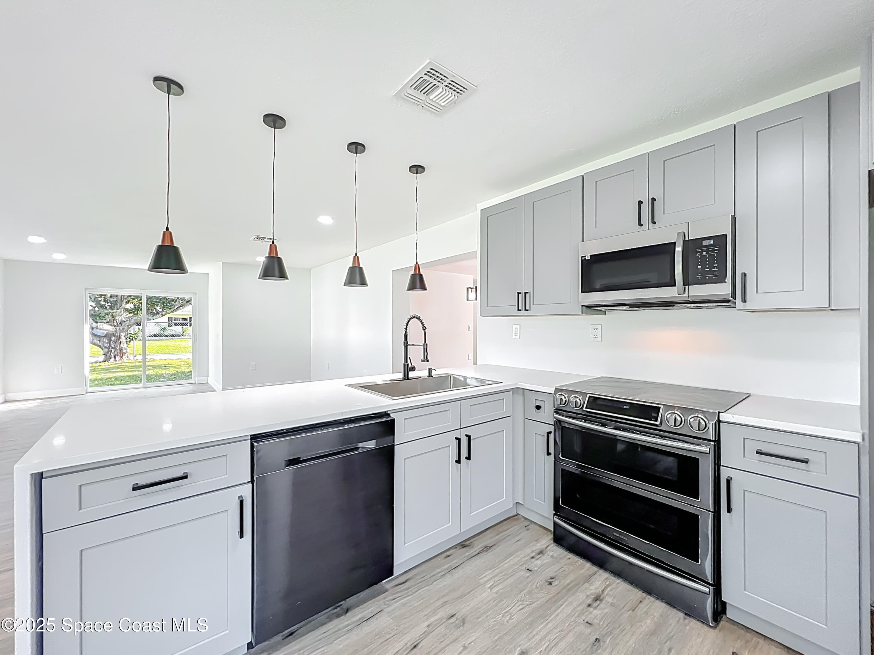 2340 Iowa Drive Melbourne, FL 32935 - Photo 6 of 47 a kitchen with a sink stove and microwave
