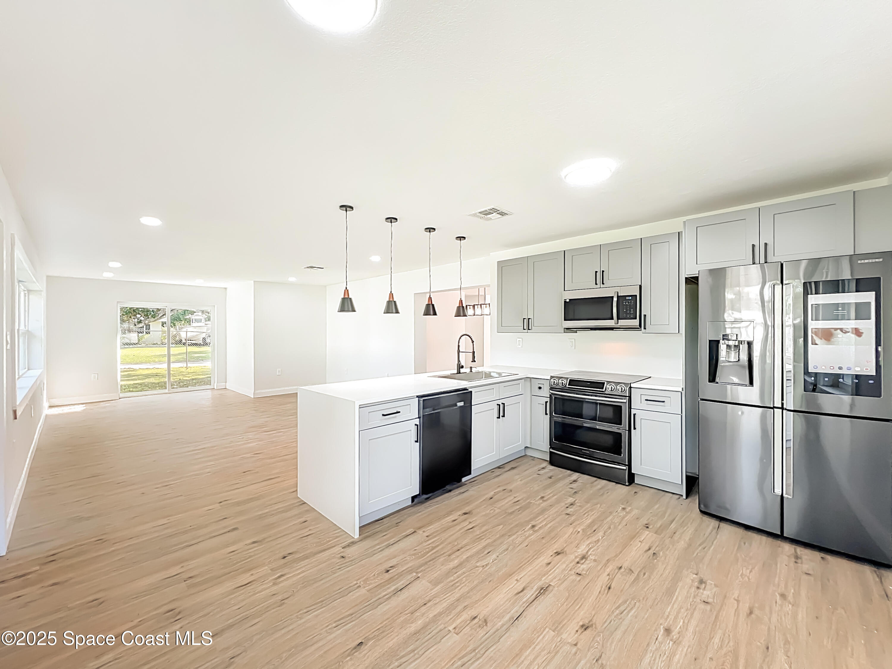 2340 Iowa Drive Melbourne, FL 32935 - Photo 8 of 47 a kitchen with granite countertop a refrigerator stove top oven and sink