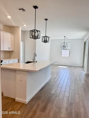a kitchen with a sink and wooden floor