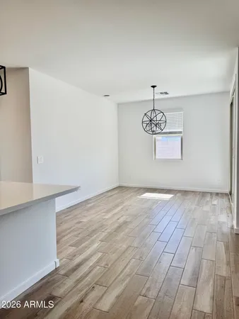 a view of a room with wooden floor and white walls