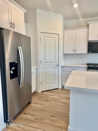 a kitchen with stainless steel appliances a refrigerator sink and white cabinets