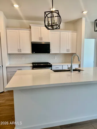 a kitchen with a sink a stove and cabinets