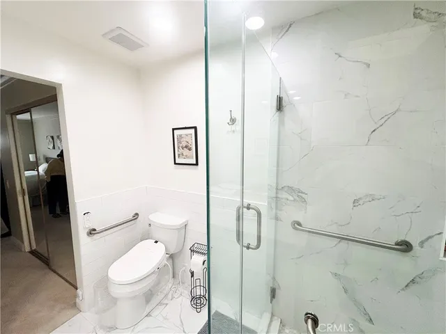 a white toilet sitting next to a bathroom sink