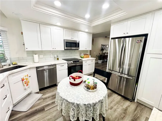 a kitchen with stainless steel appliances granite countertop a refrigerator sink stove microwave and cabinets
