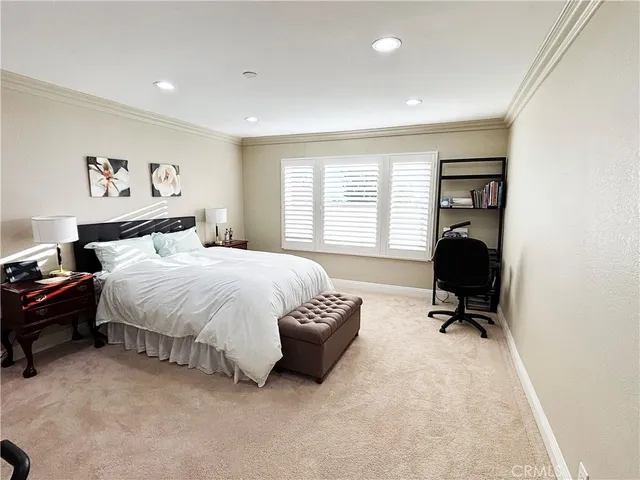 a spacious bedroom with a bed a desk and chair