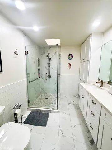 a spacious bathroom with a double vanity sink toilet mirror and bathtub