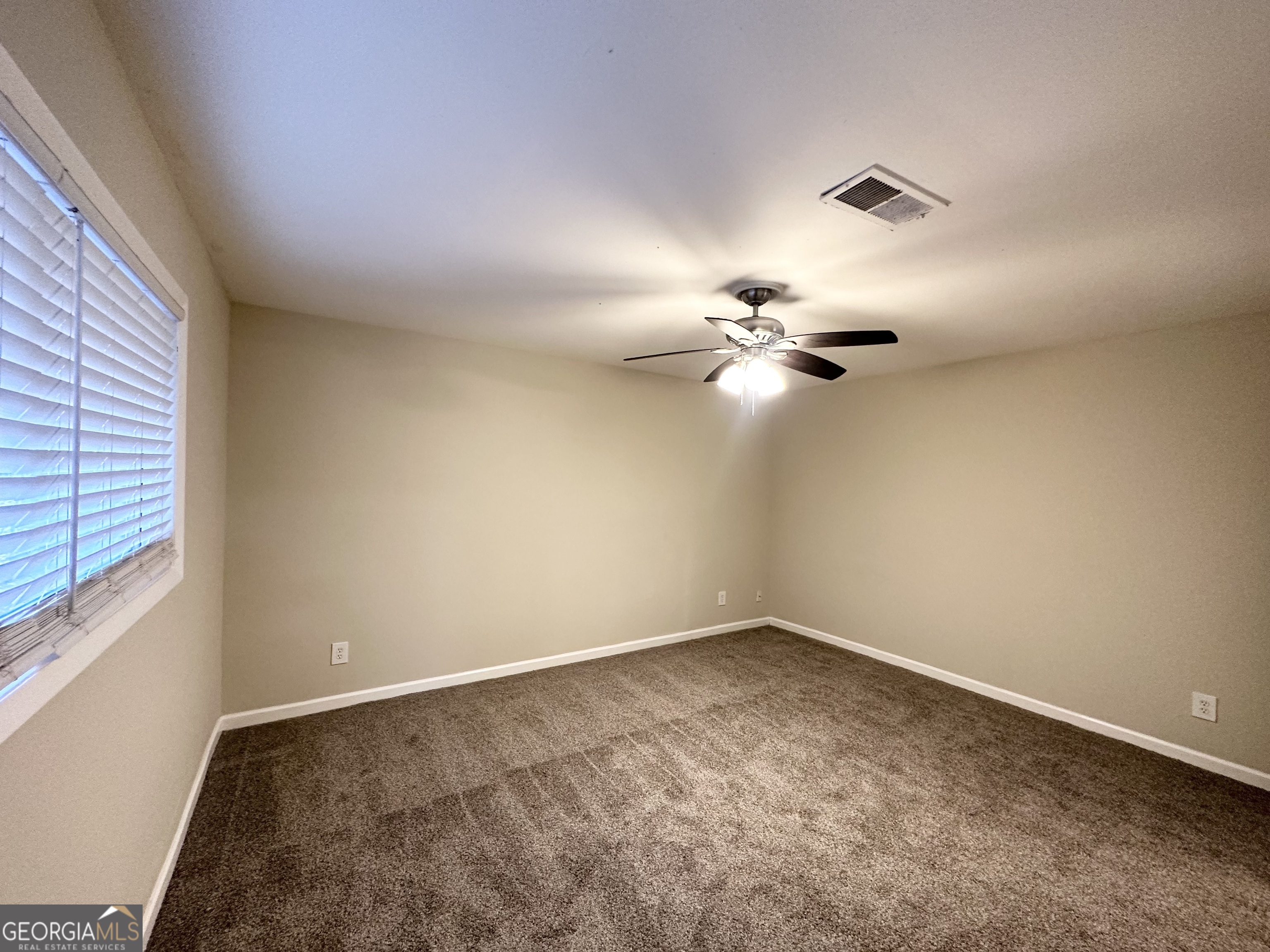 310 Flagstone Drive Southwest Atlanta, GA 30331 - Photo 11 of 13 an empty room with a chandelier fan and windows
