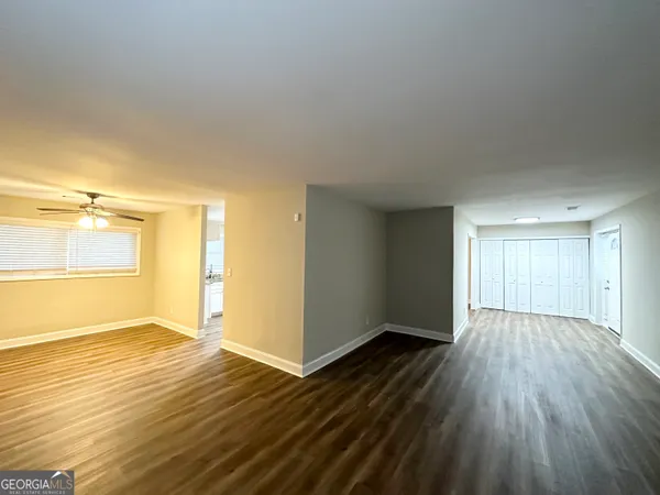 an empty room with wooden floor and windows