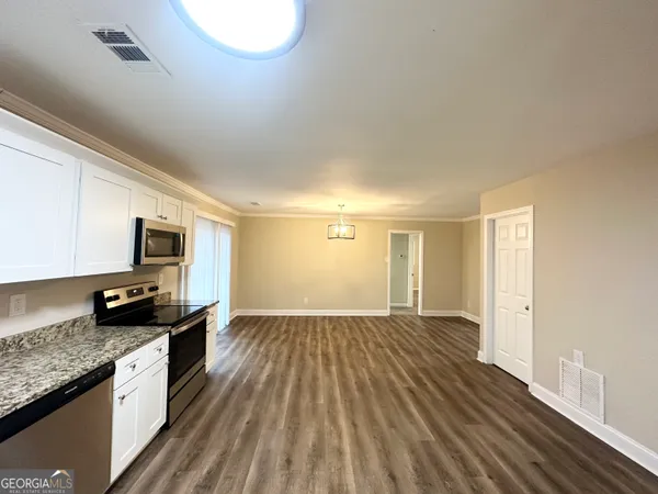 a kitchen with a sink and wooden floor